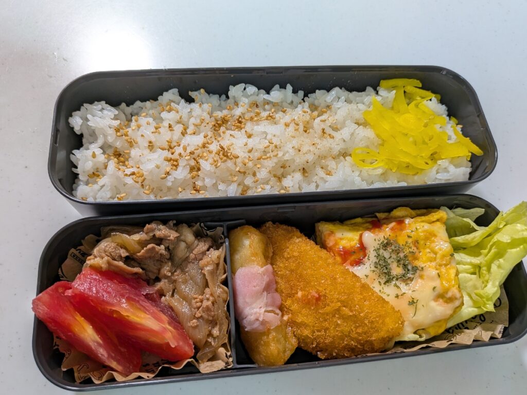 卵焼きの味付け忘れをケチャップやチーズで、ごまの不足をたくあんでリカバリーして完成させたお弁当